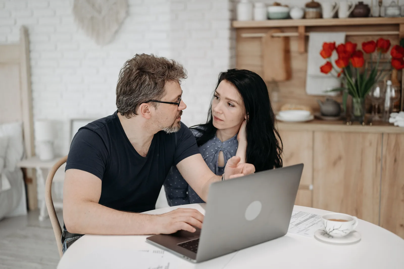A couple reviewing their retirement numbers together on a laptop at home